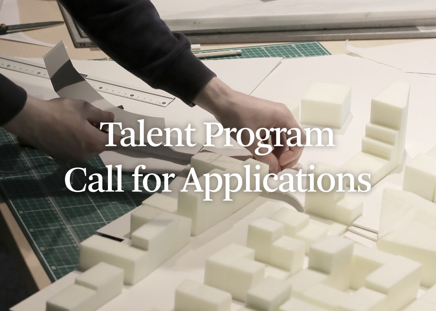 Picture of hand making a scale model with text "Talent Program Call for Applications" over it